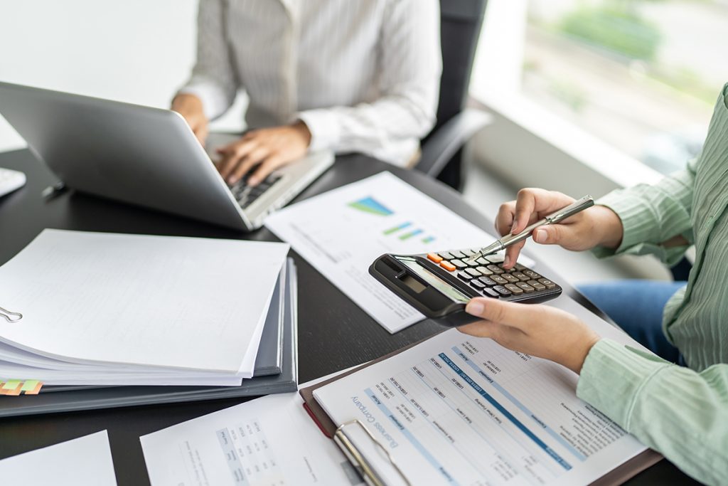 Two staff members working on calculations and reports
