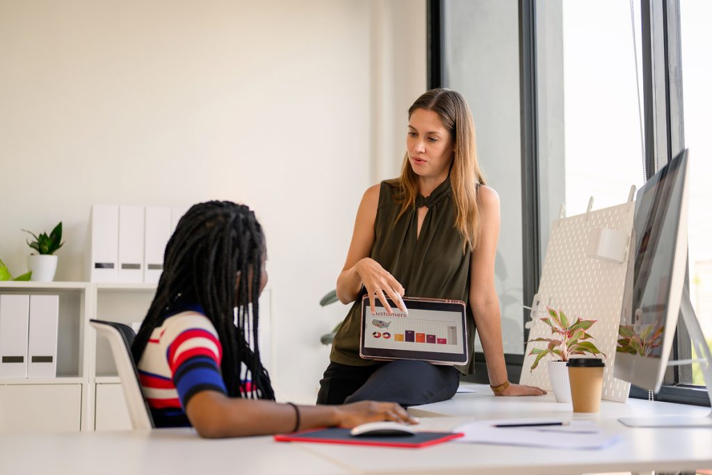 Two female professionals looking over a graph